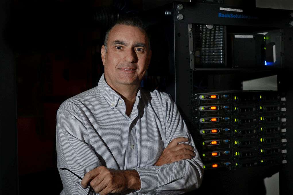 man standing with arms crossed smiling