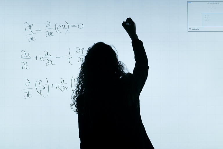 Woman write equations on smart board
