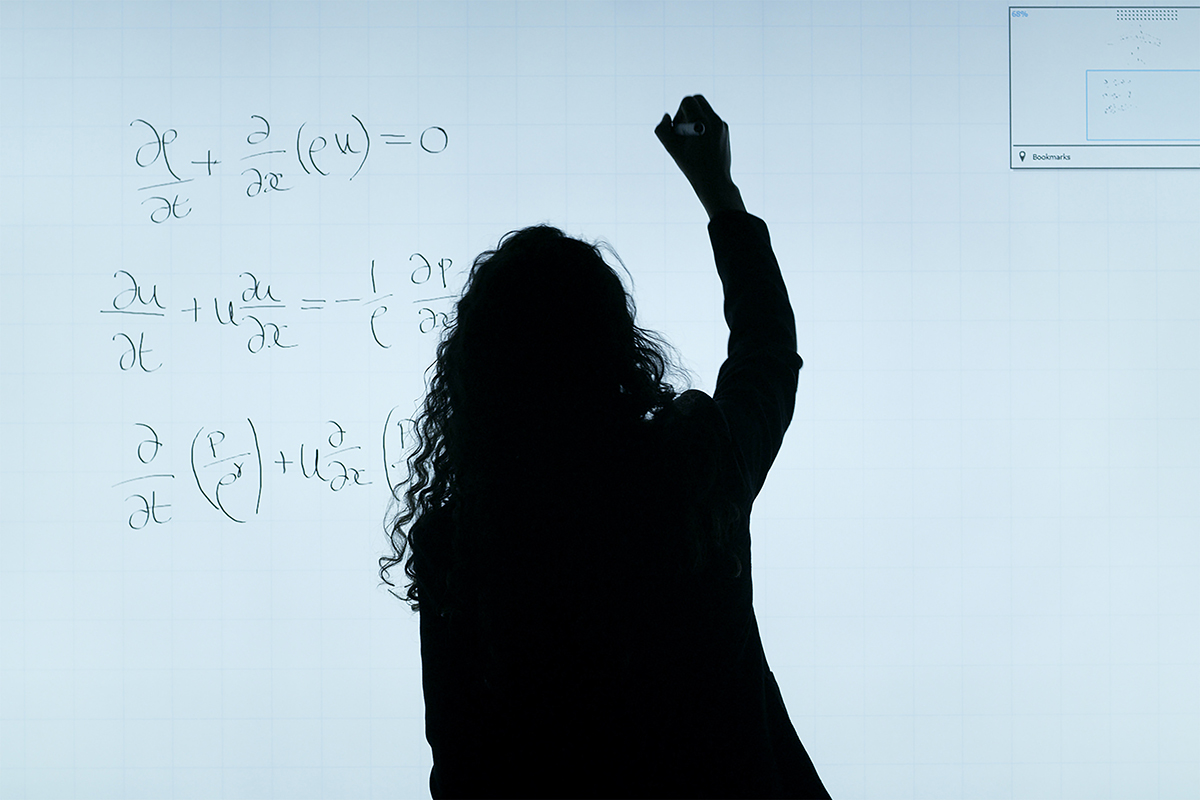 Woman write equations on smart board