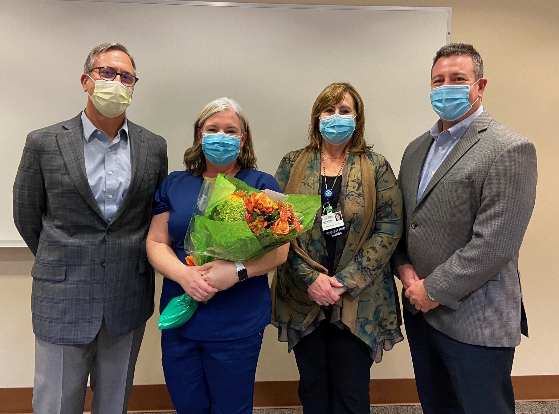 Flick holds flowers with colleagues