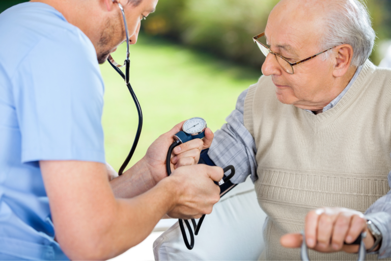 A nurse takes an elderly man's blood pressure