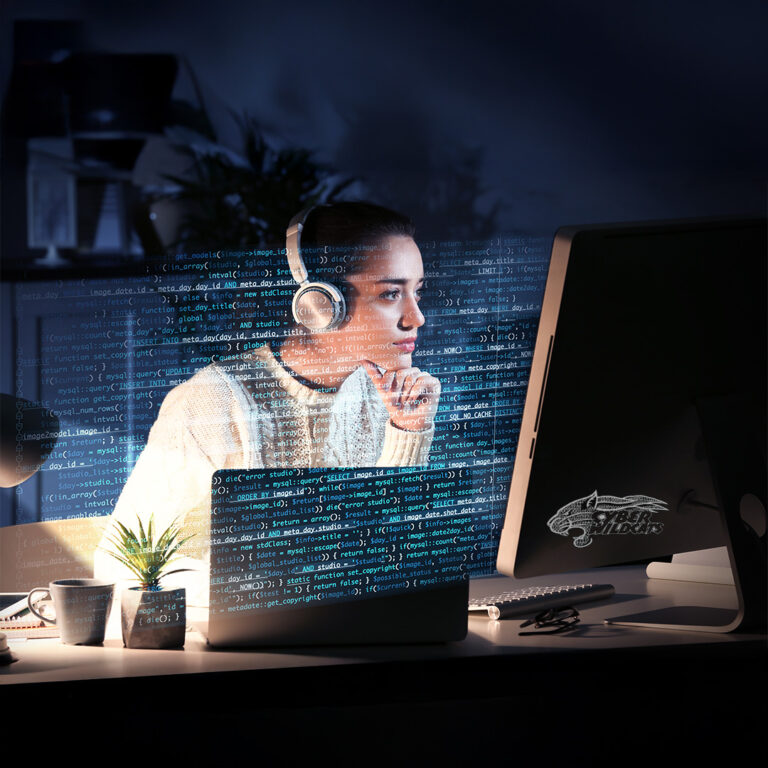 A woman with headphones works on a computer with code displayed on the screen.