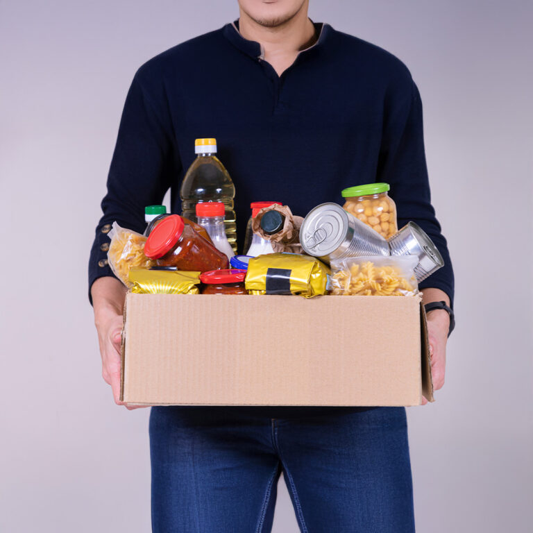 A man holding a box of shelf stable food.