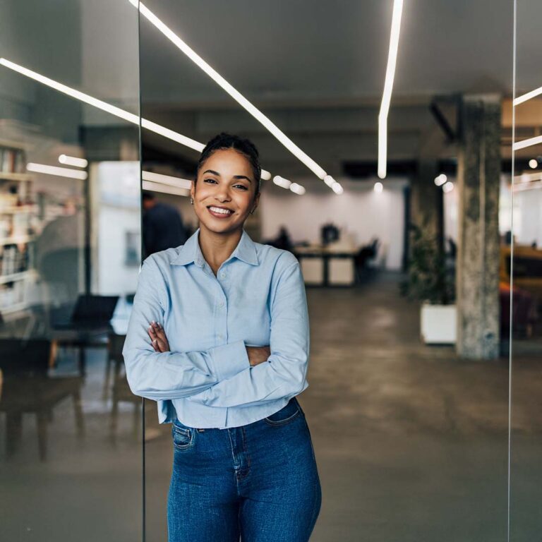 A business woman standing in a brightly lit office.