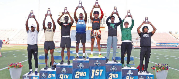 Donte Dockery holding his third-place trophy on the podium at the NCAA Division II National Championship