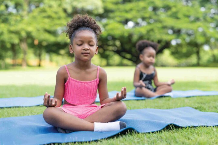 Two little girls meditating outside