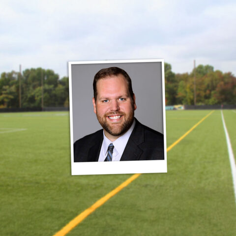 A polaroid style photo of Dr. Matt Wilson in front of the Wilmington University athletics facility.