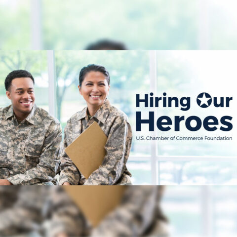 A photo of two military employees in a brightly lit room with the "Hiring Our Heroes" logo next to them.
