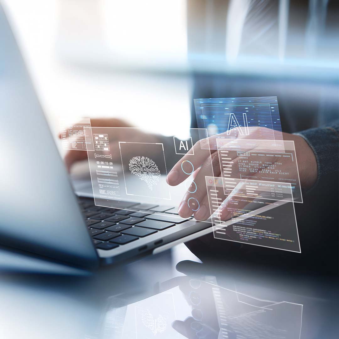 A person typing on a laptop with futuristic, translucent digital screens and AI data interfaces floating above the keyboard.