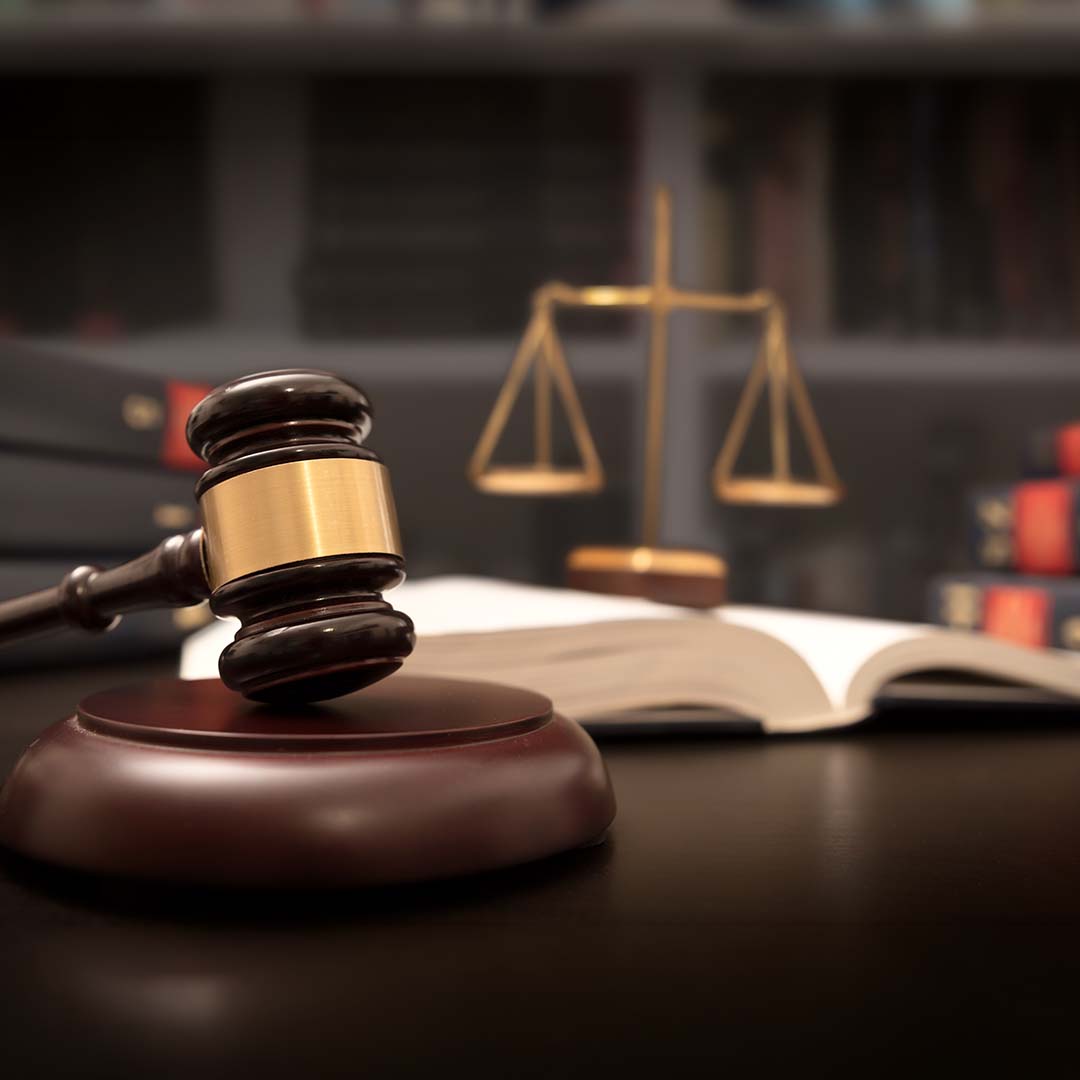 A gavel and law books on a desk.