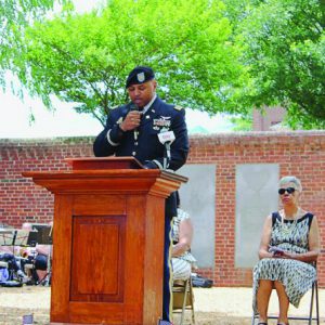 Maj Johnson speaks at a podium in uniform