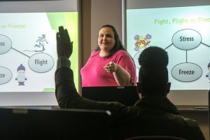 woman teaching, students' hands up