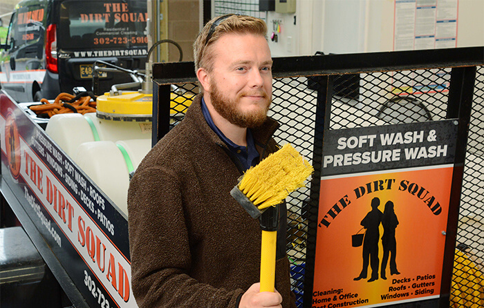 man smiling with broom