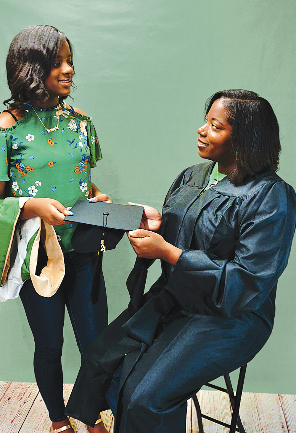Mother and daughter holding graduation cap