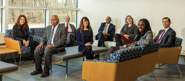 Law School faculty seated on a common space. 