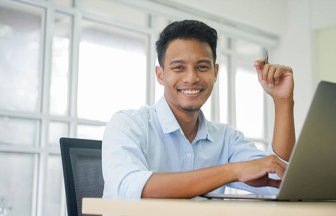 A latino man working at a computer.