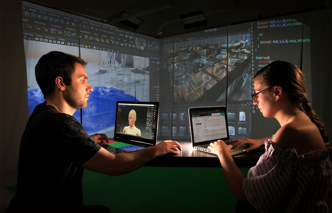 A male and female student working in a computer lab on animation software.