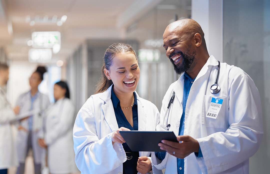 Two doctors walking down a hallway and talking.