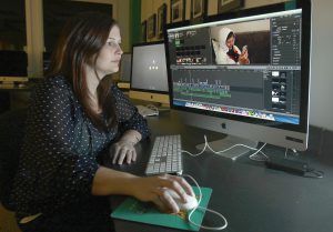 Wilmington University co-op student Kaitlin Mayhorn edits video in a classroom.